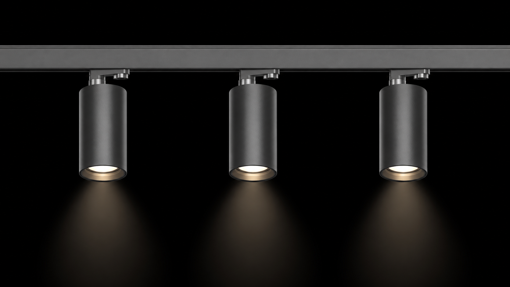 Motorized vs Traditional Track Lighting Three identical traditional fixed track light heads mounted in a row on a ceiling rail, all pointing straight down at the same angle.